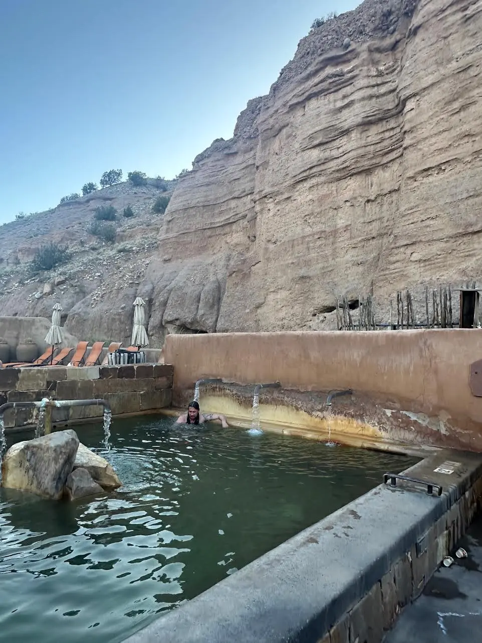 Litha pool at ojo caliente hotsprings with faucets pouting hot water over bathers
