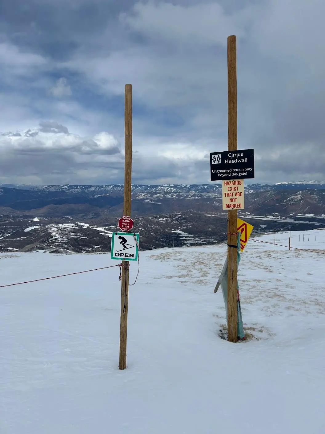 Rope entry to advanced skiing cirque terrain with warning signs